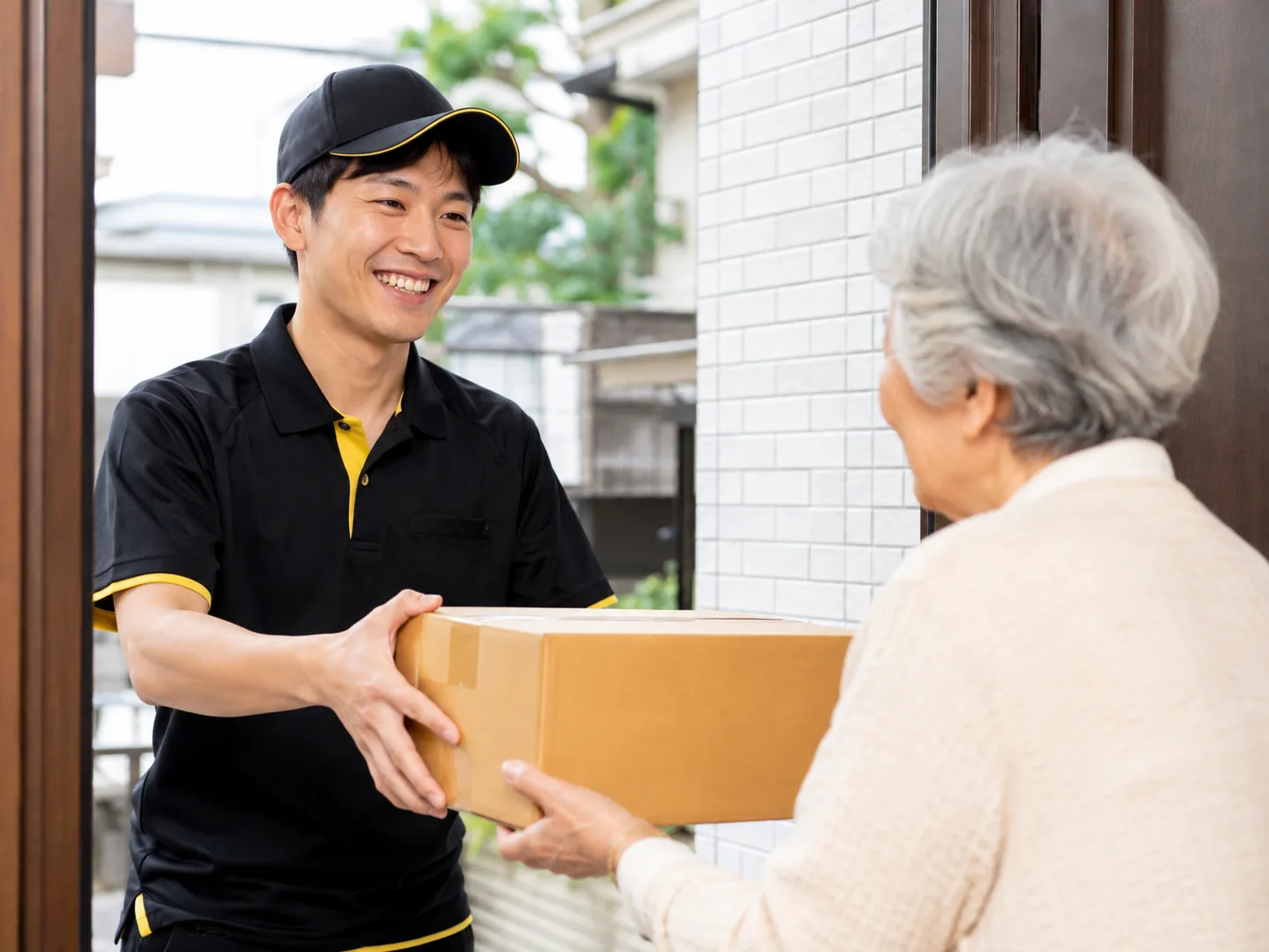 個人宅の玄関先で荷物をお届けするJUNGLEのドライバー